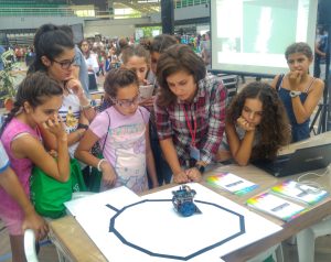 Children watching a robot on a track at the ISUS stand