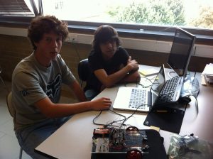 Dois alunos a programar um robô com um computador portátil