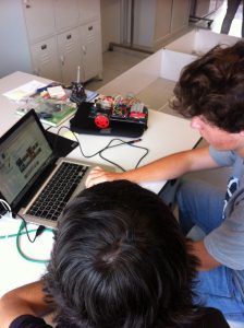 Aluno a trabalhar num computador portátil ligado a um robô