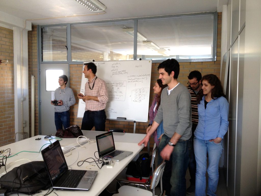 Students and researchers working together around a table with laptops in the lab