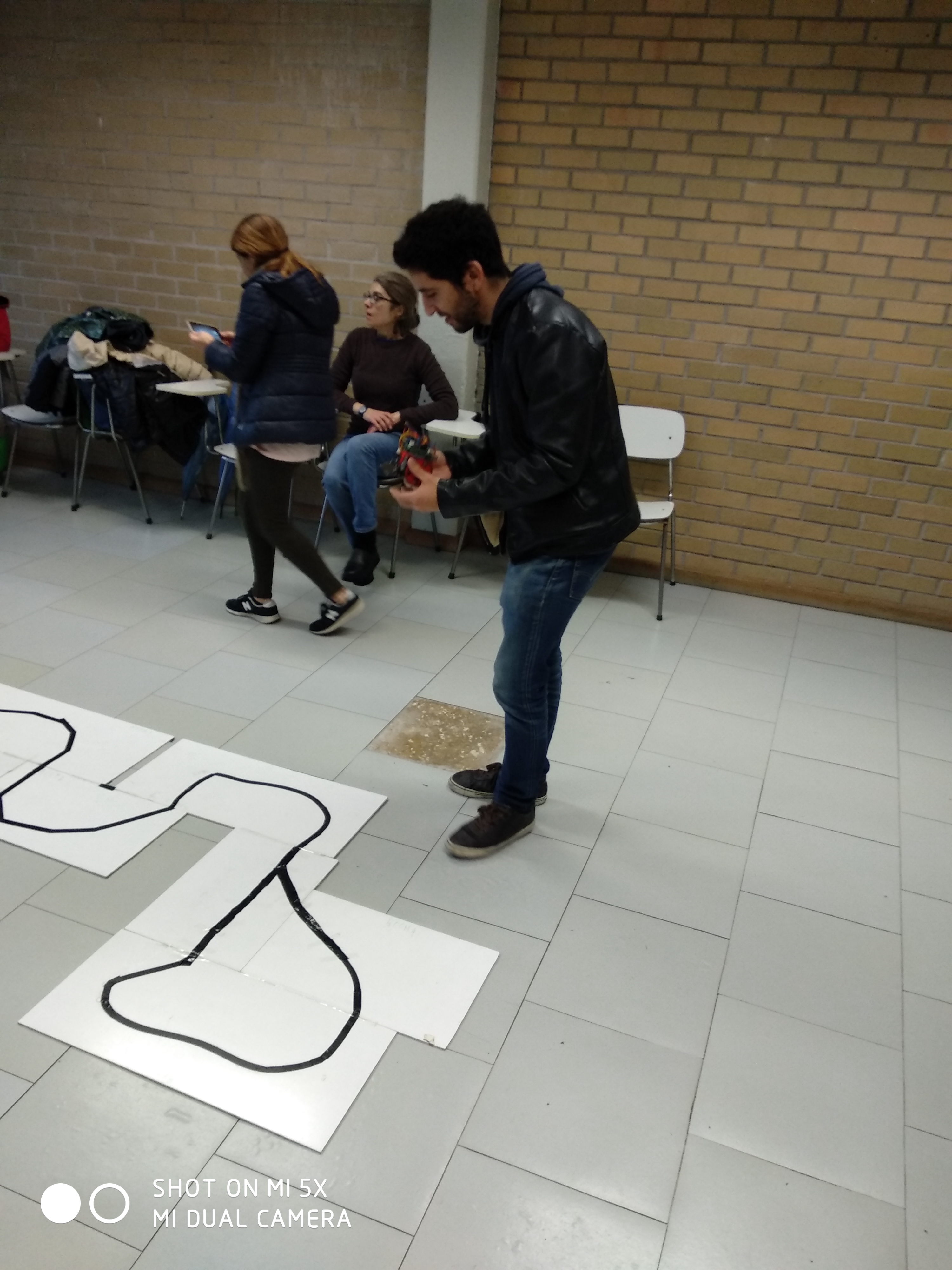 Researcher standing next to the line track for the rolling robots
