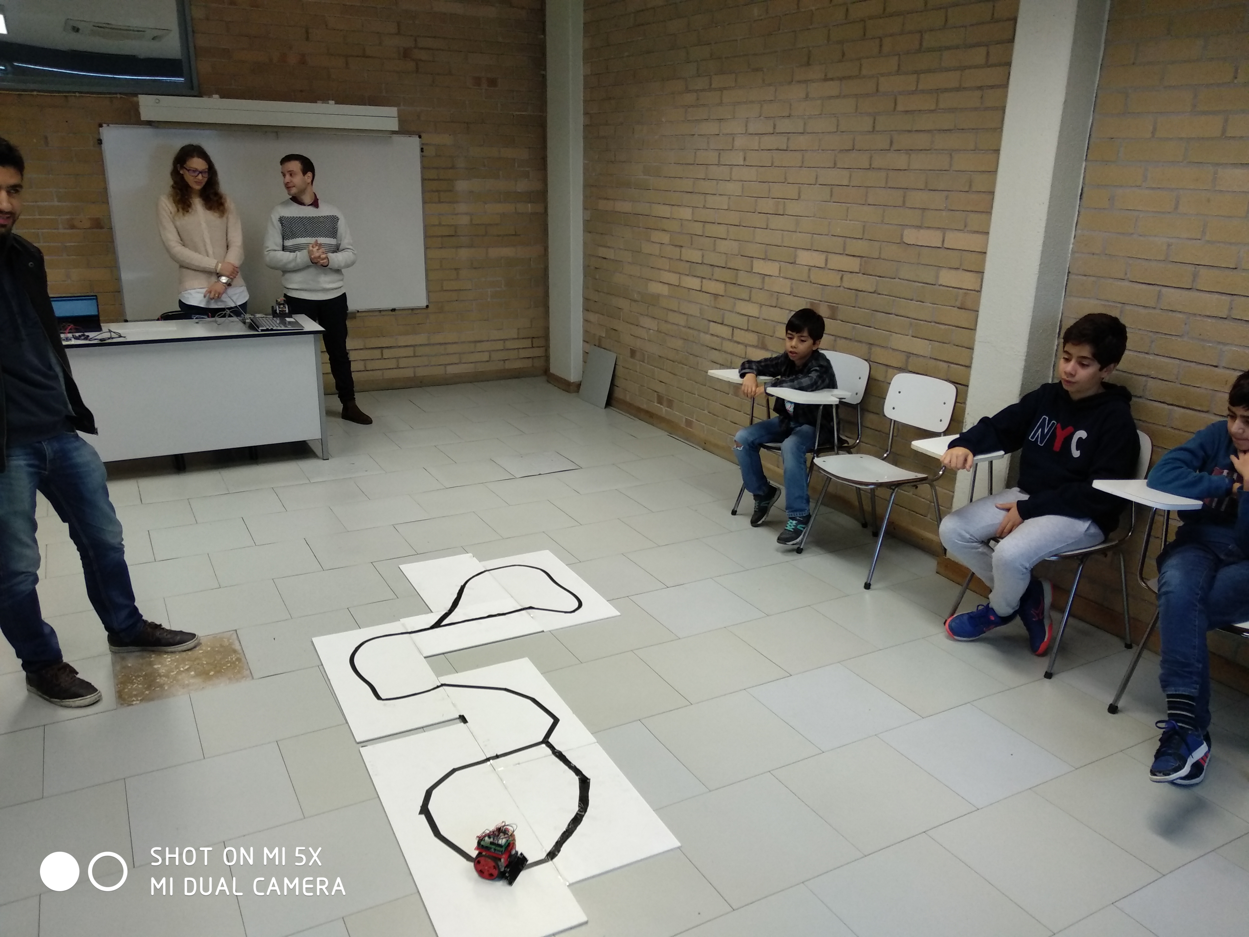 Children watching a robot on the line track