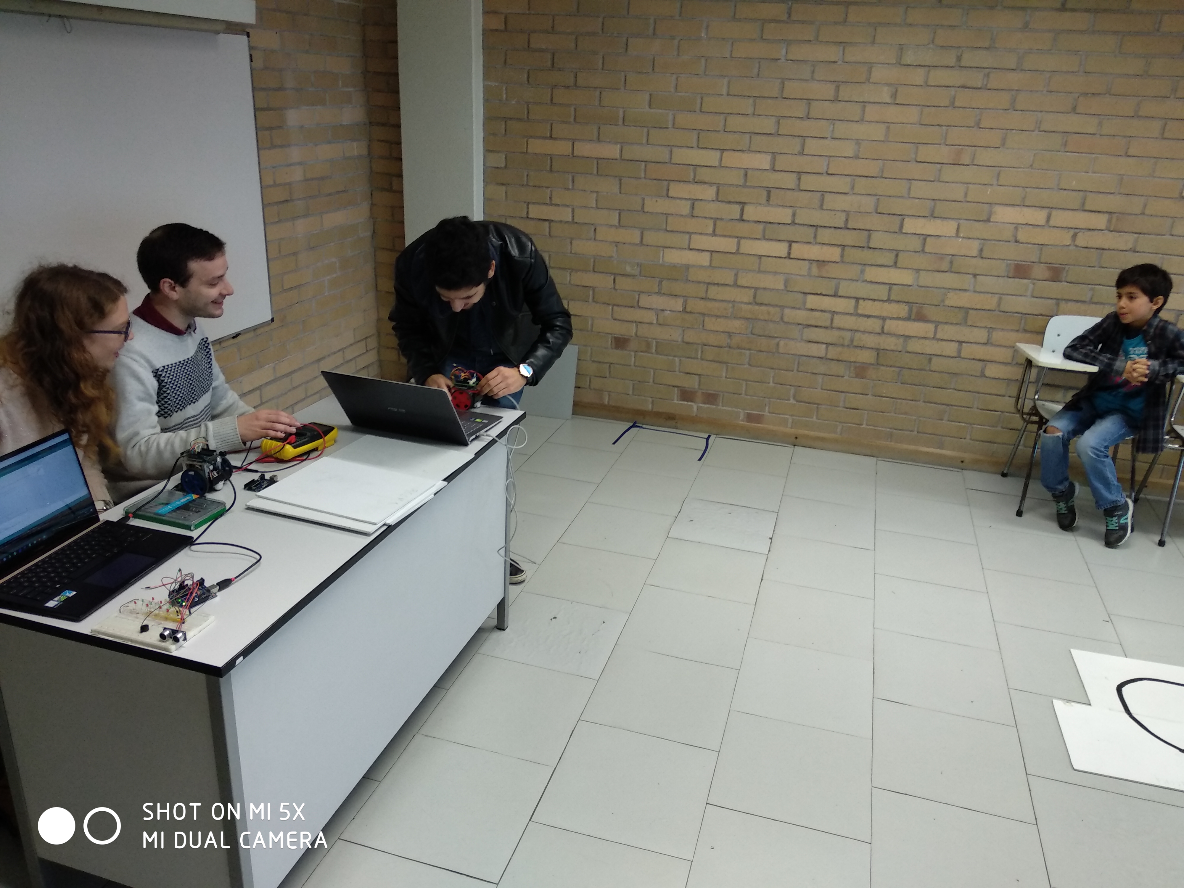 Researchers preparing laptops and robots at a desk