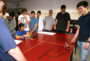 Students around a table with a line-following robot track