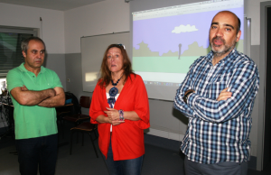 Three teachers presenting in front of a projected screen